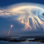 SpaceX rocket launch creating a glowing jellyfish-shaped cloud at twilight over the US east coast