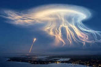 SpaceX rocket launch creating a glowing jellyfish-shaped cloud at twilight over the US east coast